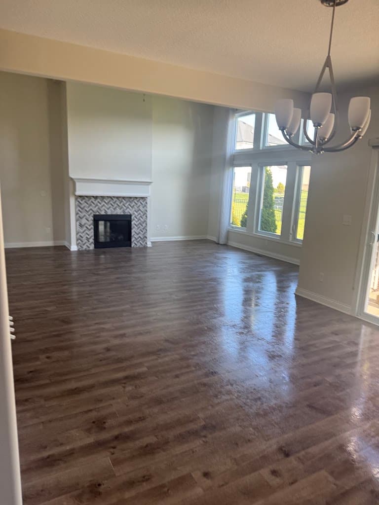 Spacious living room with clean hardwood floors and fireplace